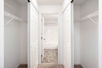 a closet in a bedroom with white doors at Cityscape, St Louis Park, Minnesota